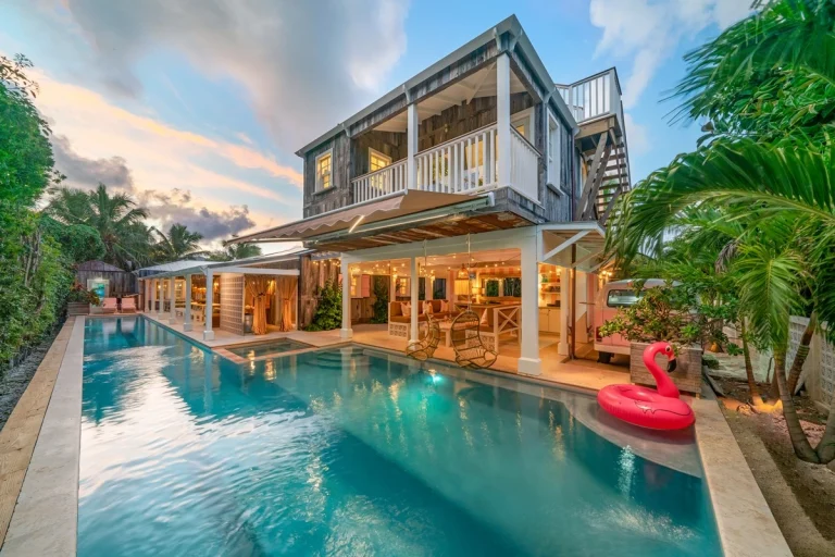 House and long pool lit at dusk at Surf Shack, Dunmore Town, Harbour Island