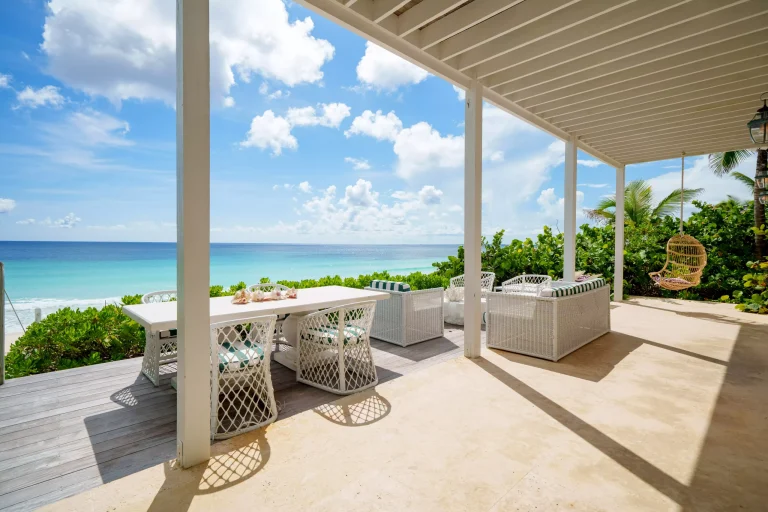 Covered deck with outdoor dining and ocean view at Sea Siren, Dunmore Town, Harbour Island