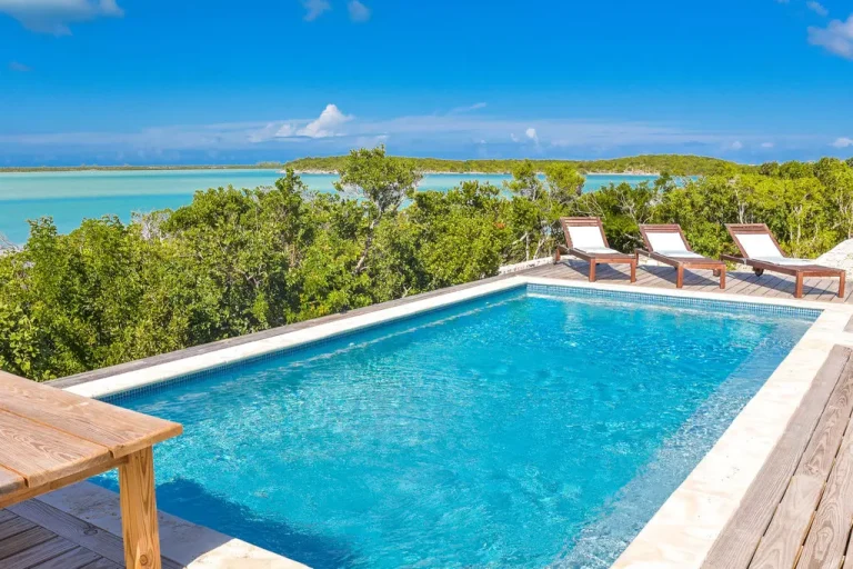 Pool with loungers and bay view at Sueno de Mar, George Town, Great Exuma