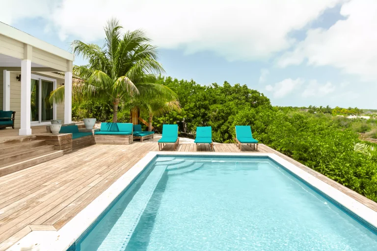 Pool deck with teal loungers at Sueno de Mar, George Town, Great Exuma