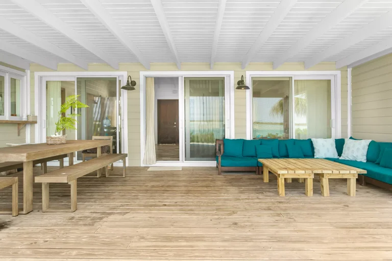 Covered deck with teal sectional at Sueno de Mar, George Town, Great Exuma