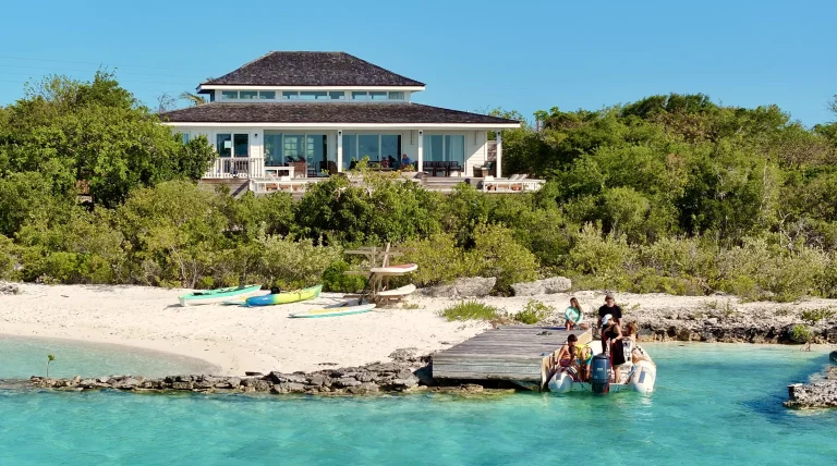 House above the beach with a boat at the dock at Surf House, George Town, Great Exuma