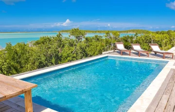 Pool with loungers and bay view at Sueno de Mar, George Town, Great Exuma