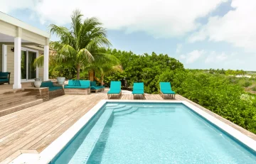 Pool deck with teal loungers at Sueno de Mar, George Town, Great Exuma