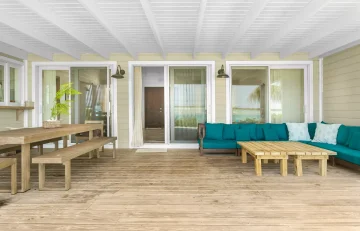 Covered deck with teal sectional at Sueno de Mar, George Town, Great Exuma