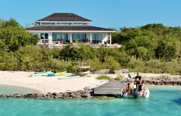 House above the beach with a boat at the dock at Surf House, George Town, Great Exuma