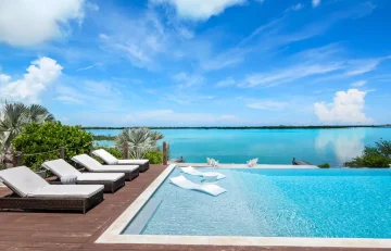 Infinity pool with loungers and bay view at Villa Exuma, Hartswell, Great Exuma